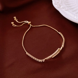 Vue macro d'un bracelet doré avec détail de clou en zircone et fermoir coulissant ajustable