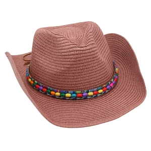 Detail of hand-woven straw cowboy hat with colorful beads and textured bohemian band