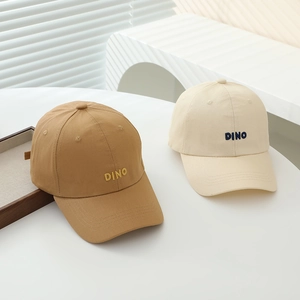 Detailed view of DINO embroidery and stitch work on kids minimalist cotton baseball caps