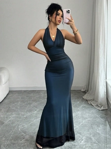 Detail of dark blue satin halter maxi dress featuring elegant waist pleats and fish tail hem