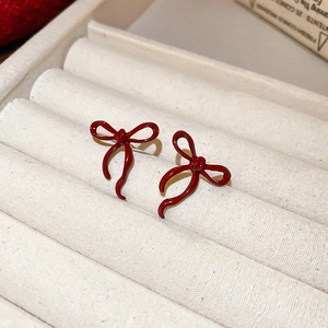 Elegant deep red bow earrings on velvet jewelry box with high-gloss enamel finish