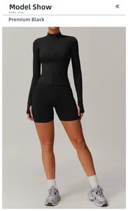 Detail of premium black yoga set featuring zip-up top with thumb holes and bike shorts