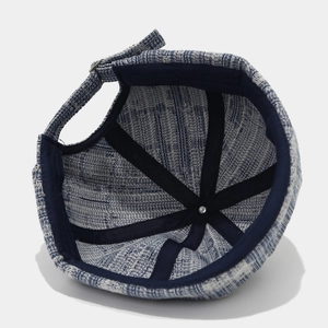 Detail view of denim docker cap interior with reinforced webbing and metal buckle