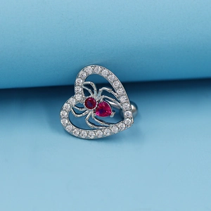 Silver spider navel ring featuring a hollow heart and a bright red heart-shaped gemstone