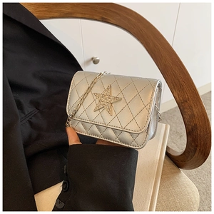 Detail of silver quilted crossbody bag with a rhinestone star buckle and chain strap