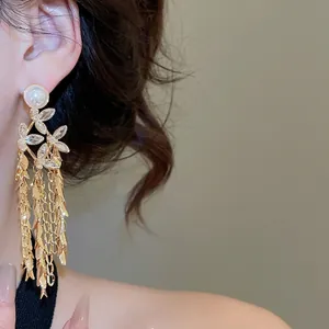 18K gold plated flower pearl stud earrings with long tassel fringe on female model