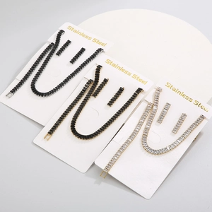 Three sets of stainless steel necklaces and earrings with cubic zirconia on display cards