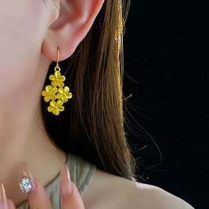 Detail of 18K gold-plated matte flower earrings showing layered petal texture and hook