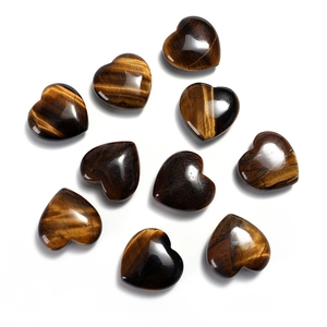 Macro shot of 10 heart-shaped polished tiger eye stone beads on a white background