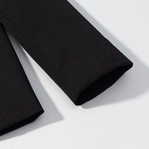 Dettaglio della cucitura del polsino e texture del tessuto su un blazer nero