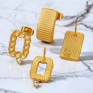Golden stainless steel earring connectors for DIY jewelry making on white marble