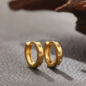 Close-up of 18K gold-plated hoop earrings with micro-inlaid zircon sun pattern charms