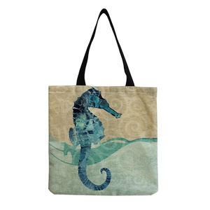 Canvas tote bag with blue seahorse print and black straps on white background