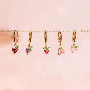 Detail of colorful tropical fruit charm earrings including strawberry and grape styles
