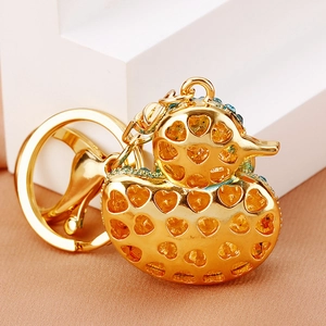 Detail of golden duck keychain with heart hollow design and blue rhinestone accents