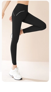 Dettaglio dei pantaloni da yoga neri a vita alta con cuciture laterali bianche sottili