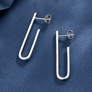 Macro shot of S925 sterling silver U-shaped stud earrings showing metal texture and hallmark