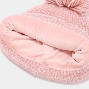 Detailed macro view of pink knit hat with thick fleece lining for winter warmth