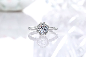 Primo piano di un anello moissanite a 6 griffe con diamanti laterali e riflesso specchiato