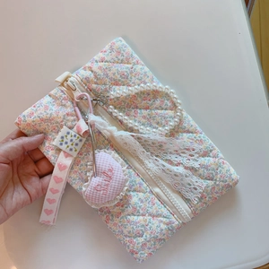 Détail du sac matelassé à fleurs roses avec anse en perles et breloque Smile