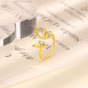 Close-up of golden hollow butterfly ring with sparkling zircons and open design