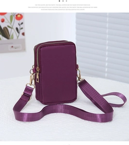 Detail view of purple nylon mini crossbody bag with double gold zippers and wide strap