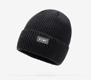Close-up of black ribbed knit beanie with FUMY patch showing fabric texture and detail