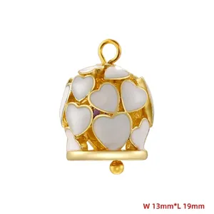 Macro detail of a 13x19mm gold bell pendant with white enamel hearts and a metal bead