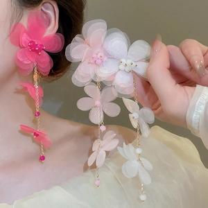 Macro view of long tassel chiffon flower earrings with mesh petals and gold chains
