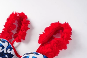 Detail of red ruffled mesh shoulder strap on Mediterranean blue floral bikini set