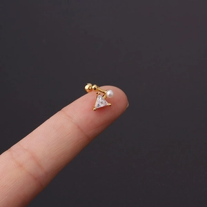 Detailed shot of gold stud earring with triangle zircon and pearl on a 20g steel post