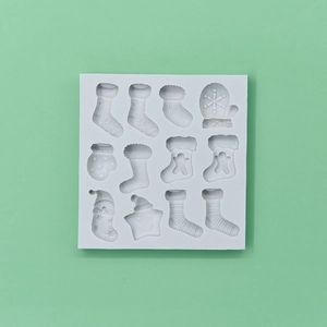 White silicone Christmas mold with 11 cavities featuring socks, mittens, and stars