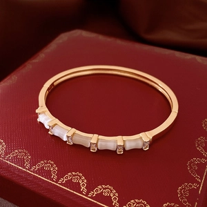 Gros plan du bracelet jonc doré style bambou avec pierres œil-de-chat et zircons