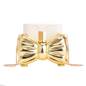 Glossy gold bow-shaped acrylic clutch bag with a sleek metal chain for fashion use