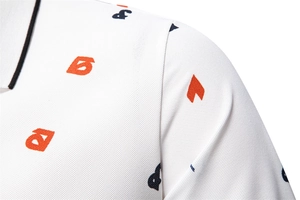 Dettaglio del tessuto piqué della polo bianca con stampe grafiche arancioni e blu scuro