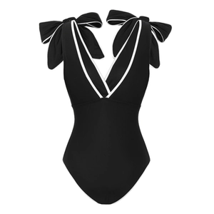 Detail view of the black one-piece swimsuit featuring white trim and large shoulder bows