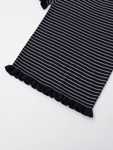 Détail du tissu en maille rayé noir et blanc avec un ourlet à volants élégant