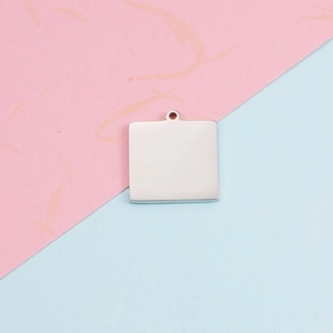 Polished silver square titanium steel pendant with hole on pink and blue background