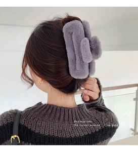 Detail of large grey plush wavy hair claw clip worn on model back of head
