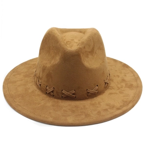Close-up of brown suede fedora featuring decorative leather band with X-shaped cross stitching