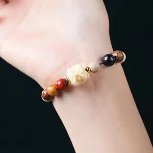 Bracciale artigianale di perle di legno multicolore con leone scolpito in avorio vegetale