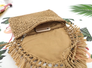 Detail of paper rope straw bag with fringe tassel showing interior phone capacity
