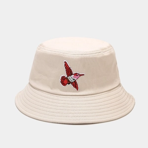 Close-up of hummingbird embroidery on beige cotton bucket hat with reinforced stitching