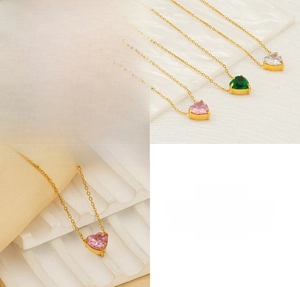 Detailed macro view showing pink green and white zircon heart pendants on stainless steel chains