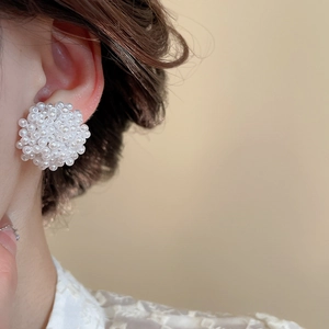 Primo piano di eleganti orecchini a perno con perle su una modella dal design lussuoso