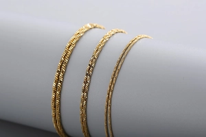 Detailed view of three gold stainless steel snake chains in varied thicknesses