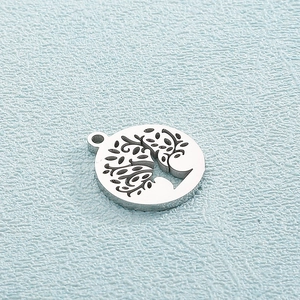 Detailed view of silver titanium steel circular pendant featuring a hollow Tree of Life design
