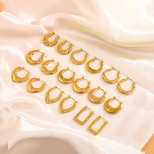 Vari orecchini a cerchio in acciaio inossidabile placcati oro 18K su seta bianca