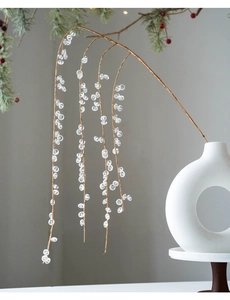Close-up of clear acrylic crystal beads on branches in a ceramic vase for Christmas
