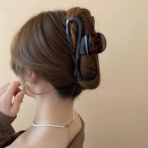 Detail of vintage leopard print shark hair claw clip styled on woman's updo hairstyle